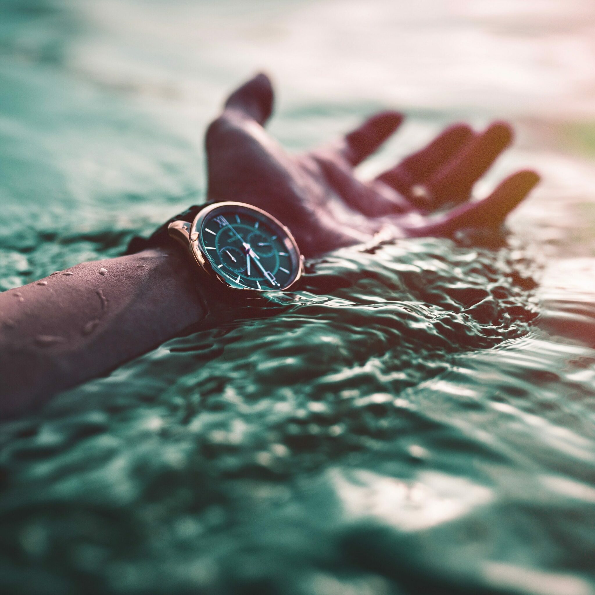 A waterproof watch partially submerged in water. Check out our watch cleaning guide to find the best way to clean your waterproof watch.