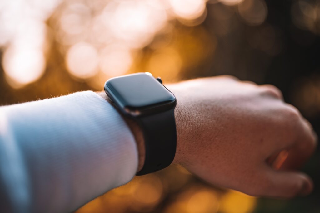 An image of a person wearing a smart watch with a rubber watch band. 