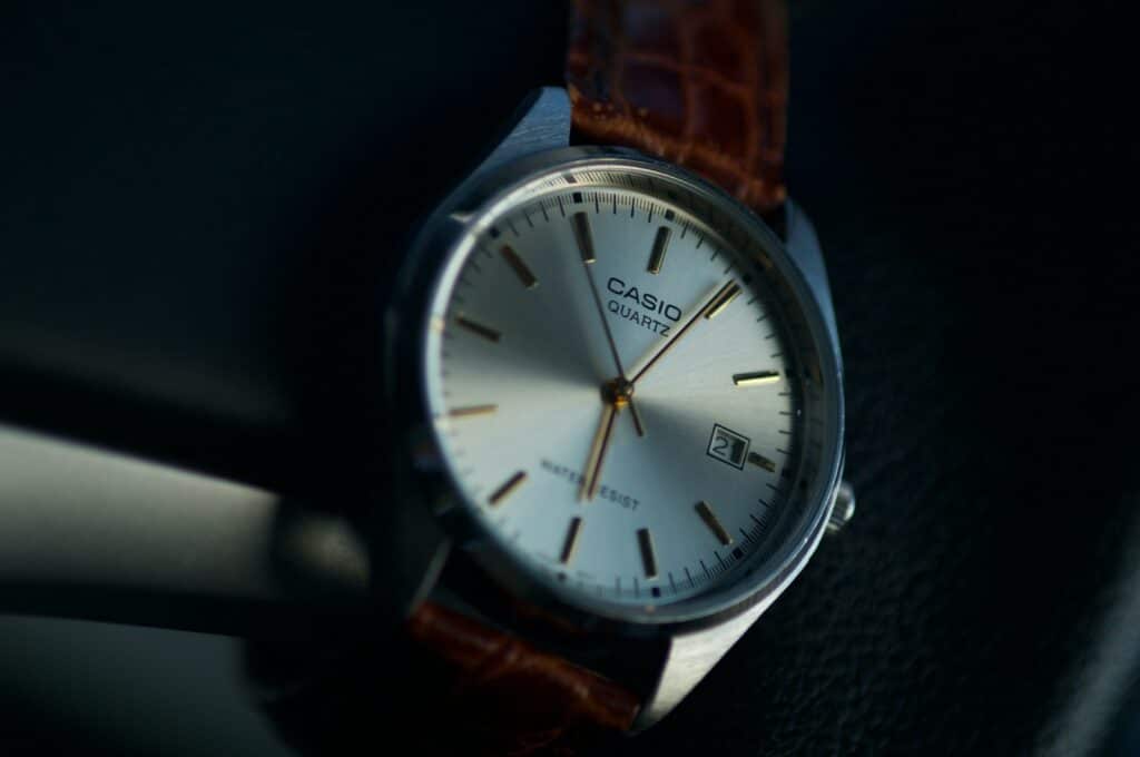 Closeup of a quartz watch with a brown leather strap. An image to accompany our guide on how to save money when buying a watch.